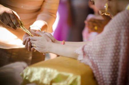 hands pouring blessing water into bride's bands, Thai wedding ceremonyの写真素材