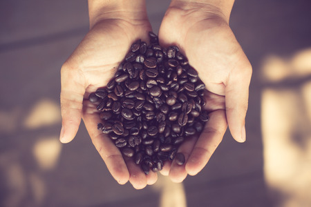 Coffee beans in hands vintage colorの写真素材
