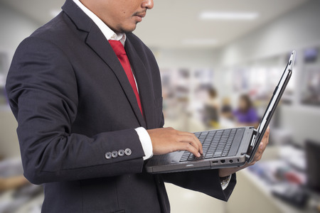 Businessman working on a laptop office backgroundの写真素材
