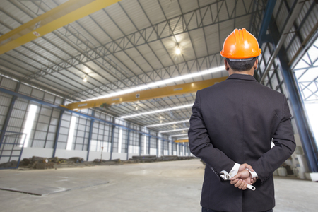 engineer holding orange helmet for workers security on factory backgroundの写真素材