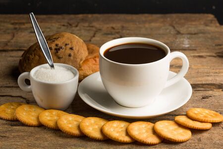 Cup of coffee on a wooden board and biscuitsの写真素材