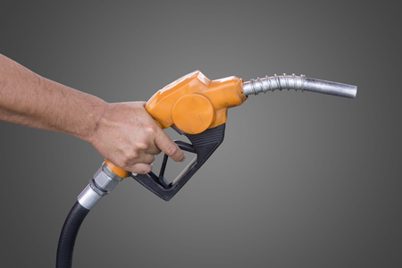 Holding a fuel nozzle against grey backgroundの写真素材