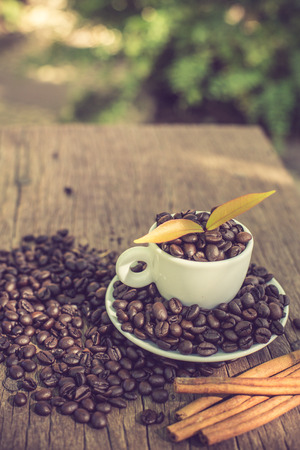 Coffee cup and coffee bean on a wooden table and Coffee plant.vintage colorの写真素材