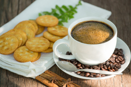 Cup of coffee on a wooden board and biscuitsの写真素材