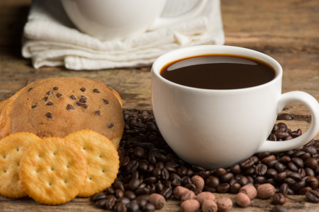 Cup of coffee on a wooden board and biscuitsの写真素材