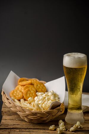 Beer Glass and Popcorn on a Wooden Backgroundの写真素材