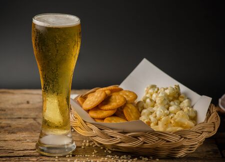 Beer Glass and Popcorn on a Wooden Backgroundの写真素材