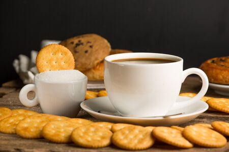Cup of coffee on a wooden board and biscuitsの写真素材