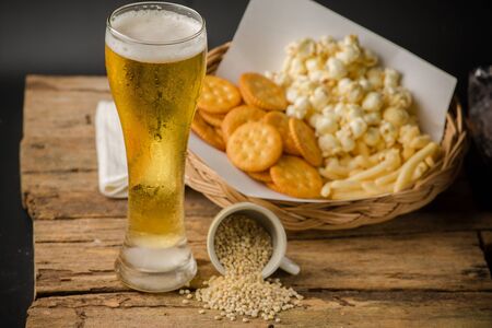 Beer Glass and Popcorn on a Wooden Backgroundの写真素材