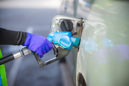 Gas pump nozzle in the fuel tank of a bronze car.の写真素材