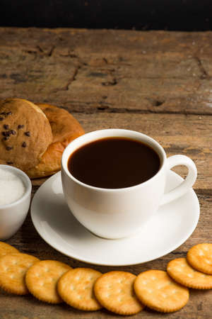 Cup of coffee on a wooden board and biscuitsの写真素材