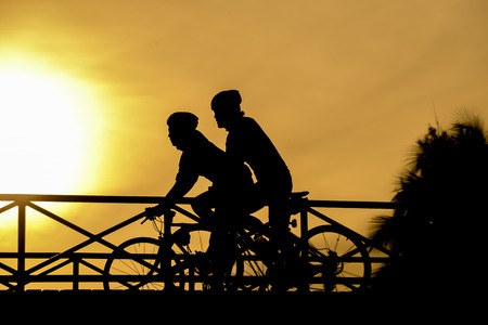 silhouette of biker on Bridge and sunsetの写真素材