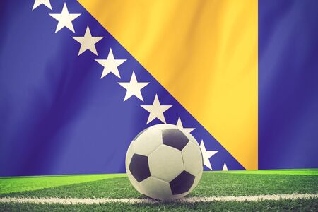 Soccer ball and national flag of Bosnia and Herzegovina lies on the green grass vintage colorの写真素材