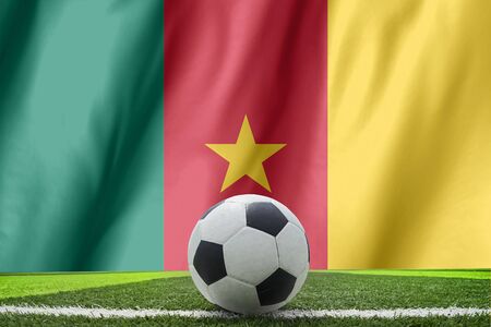 Soccer ball and national flag of Cameroon lies on the green grassの写真素材