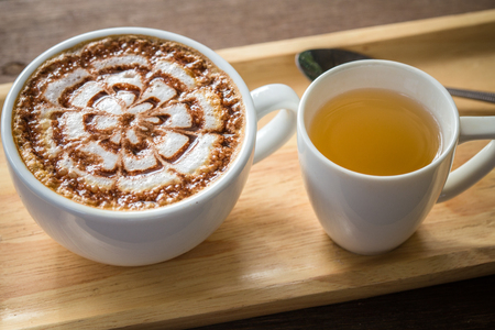 Latte Coffee art on the wooden desk with tea cupの写真素材