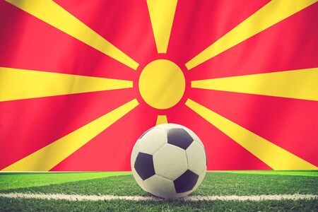 Soccer ball and national flag of Macedonia lies on the green grass vintage colorの写真素材