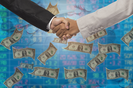 Business handshake. Business handshake and business people concept. Two men shaking hands over money backgroundの写真素材