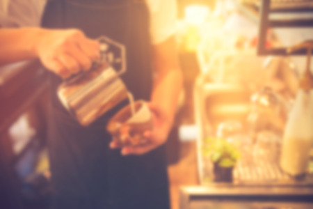 barista offering a cup of coffee to you at the coffee shop. Blurred background.Vintage colorの写真素材