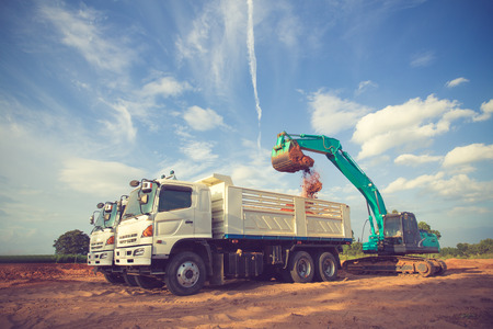 construction site digger, excavator and dumper truck. industrial machinery on building site.Vintage colorの写真素材
