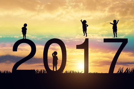 silhouette of children jumping on the sunset and 2017 years while celebrating new year