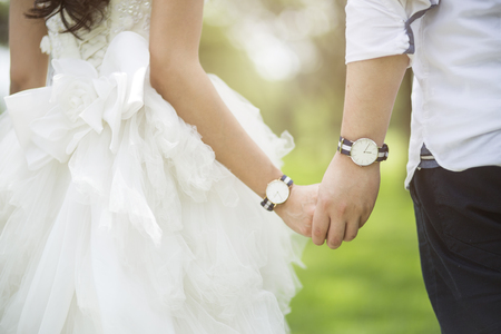 Wedding couple holding hands on sunset background.Soft focusの写真素材