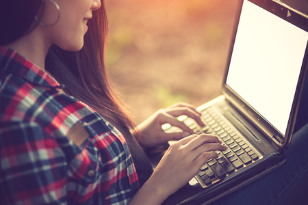 Euphoric woman searching job with a laptop in an urban park in summer.Vintage colorの写真素材