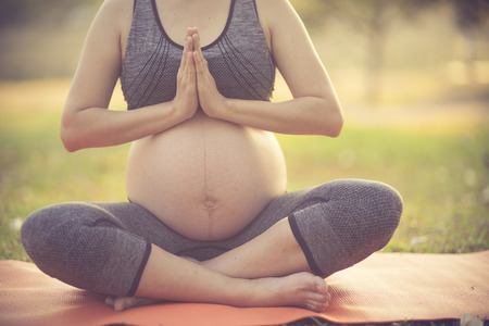 healthy pregnant woman doing yoga in nature outdoors.Vintage colorの写真素材