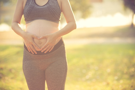 Image of pregnant woman touching her belly with handsの写真素材
