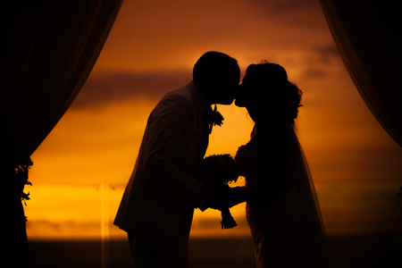 Romantic couple kissing at sunsetの写真素材