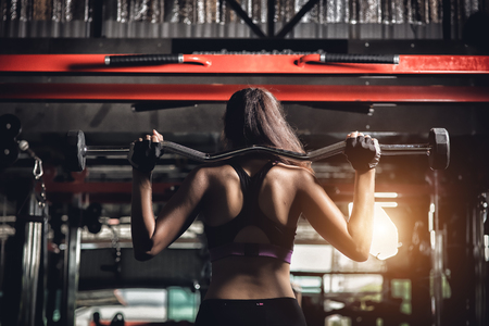 young fitness woman execute exercise with exercise-machine in gymの写真素材