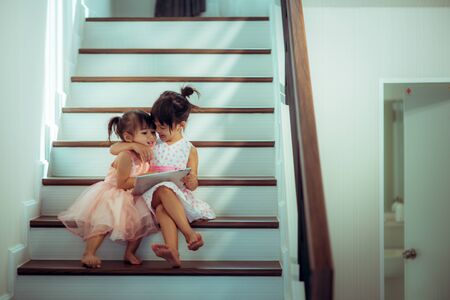 Cheerful children with smartphones in hands playingの写真素材