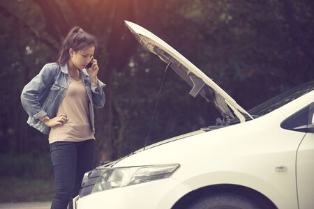 Young woman with broken car calling for help.Vintage color