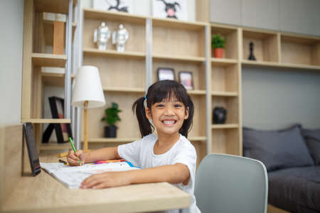 Covid-19 Coronavirus and Learning from home, Home school kid concept. Little children study online learning from home with laptop.の写真素材