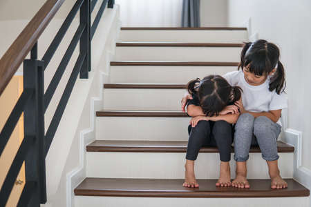 ittle girl comforting her sister at home
