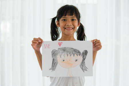 Cute little preschooler child drawing yourself at home