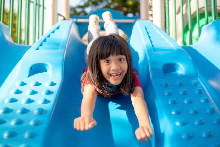 Cute little girl having fun on a playground outdoors in summerの写真素材