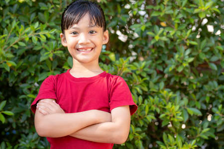 Happy Little asian girl child showing front teeth with big smile and laughing: Healthy happy funny smiling face young adorable lovely female kid.Joyful portrait of asian elementary school student.の写真素材