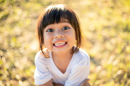 Happy Little asian girl child showing front teeth with big smile and laughing: Healthy happy funny smiling face young adorable lovely female kid.Joyful portrait of asian elementary school student.の写真素材
