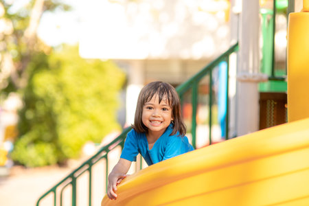 Cute little girl having fun on a playground outdoors in summerの写真素材