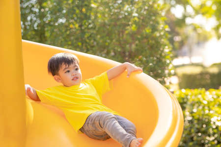Child playing on the outdoor playground. Kids play in school or kindergarten yard. Active kid on...