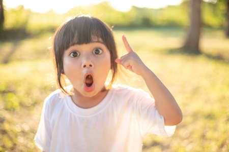 Asian Little Girl smiling and pointing up with the fingerの写真素材