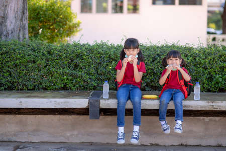 Kids eating outdoors at the school. Healthy school breakfast for children. Sandwich time.の写真素材
