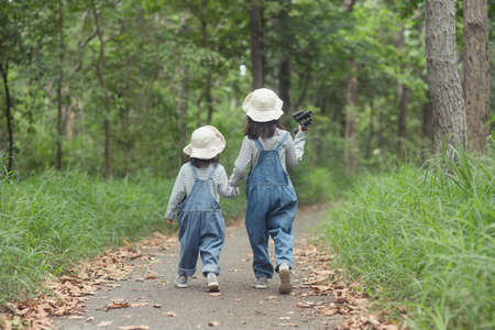 Children are heading to the family campsite in the forest Walk along the tourist route. Camping road. Family travel vacation concept.の写真素材