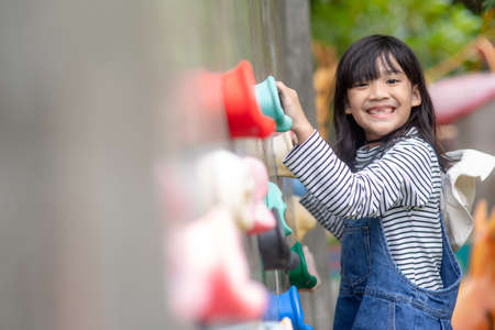 Asian little girl climbing a rock wallの写真素材