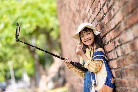 Happy kid girls taking selfies. taking selfie photos with a smartphoneの写真素材