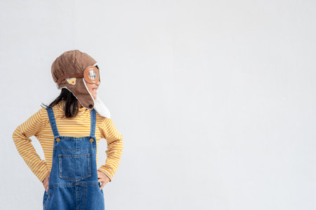 A little child girl in an astronaut costume is playing and dreaming of becoming a spaceman. on white backgroundの写真素材
