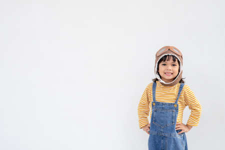dreams of flight! little child girl playing with a pilot hat on white backgroundの写真素材