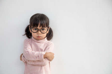 Angry little girl over white background, sign and gesture conceptの写真素材
