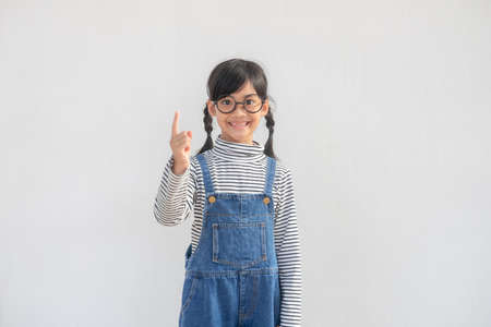 Asian student girl over white background pointing finger up with a successful idea. Excited and happy. Number onの写真素材