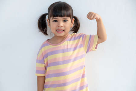 Happy Asian children showing her strong handsの写真素材